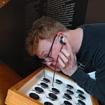 Man wearing glasses and ear buds listening to something interesting