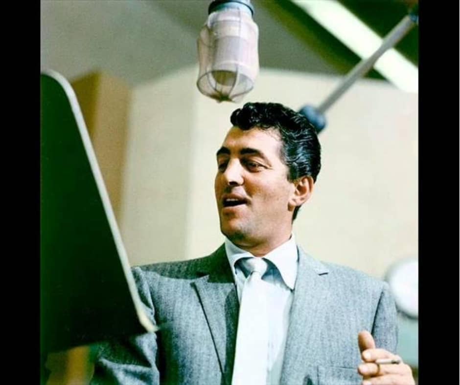 Dean Martin sings into a microphone